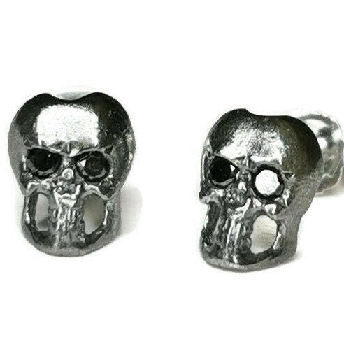 a pair of skull studs with diamonds in eyes