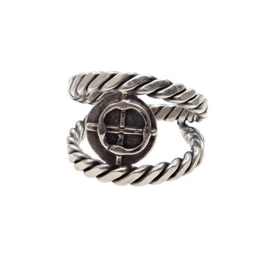 The rope ring with the coin in the pirate style is slightly turned sideways on the white background